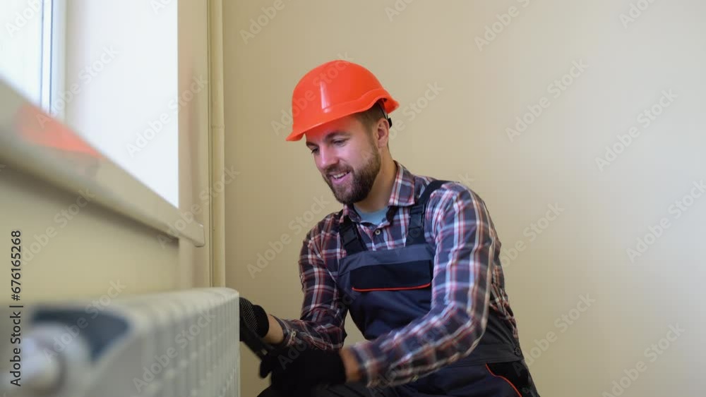 Plumber installing radiator in a new apartment Plumber installing radiator in a new apartment