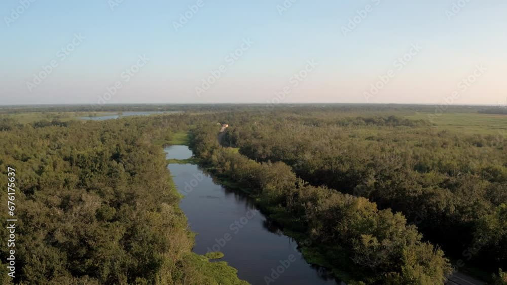 Aerial Panning Shot Of Atchafalaya River Amidst Green Trees Against Clear Sky - Bayou, Louisiana Aerial Panning Shot Of Atchafalaya River Amidst Green Trees Against Clear Sky - Bayou, Louisiana
