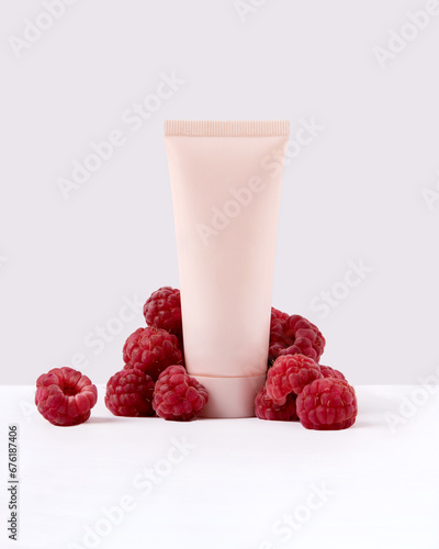 tube with cream surrounded by raspberries. The concept of natural cosmetics, body and face care