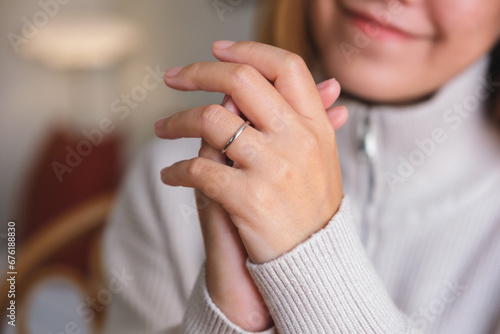 Closeup image of a young woman wearing silver ring on her finger