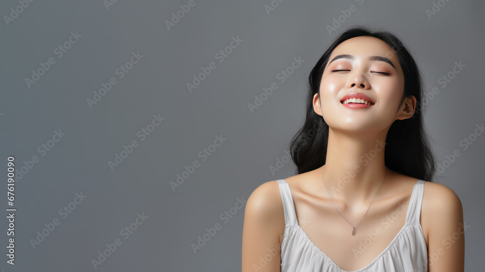 A asian woman breathing calmly looking up isolated on gray background A asian woman breathing calmly looking up isolated on gray background