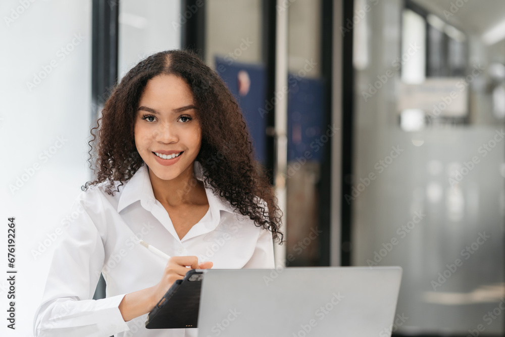 Female businessmen sitting at the desk, looking to camera. Female businessmen sitting at the desk, looking to camera.