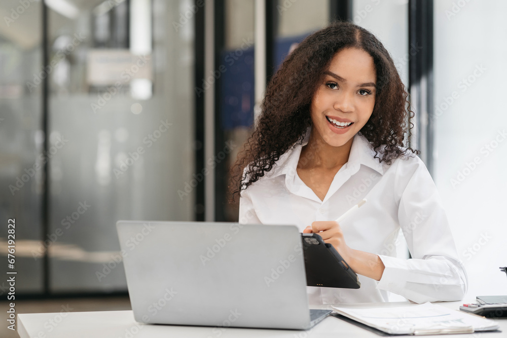 Female businessmen sitting at the desk, looking to camera. Female businessmen sitting at the desk, looking to camera.