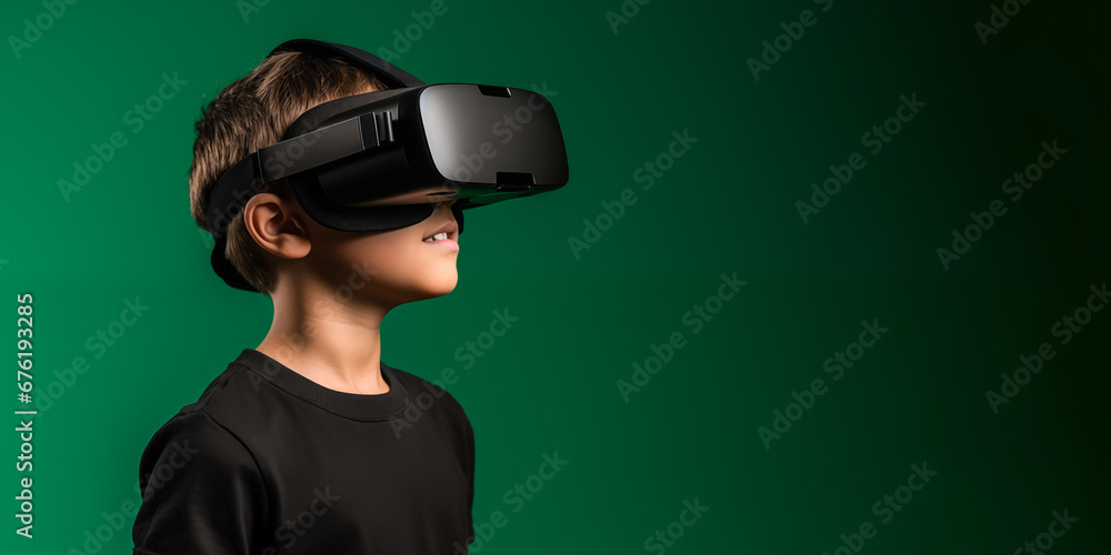 Young boy getting experience using VR headset glasses isolated on a green background with copy space Young boy getting experience using VR headset glasses isolated on a green background with copy space