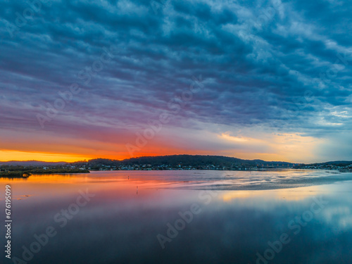 Heavy cloud covered sunrise over the bay with colour and reflections