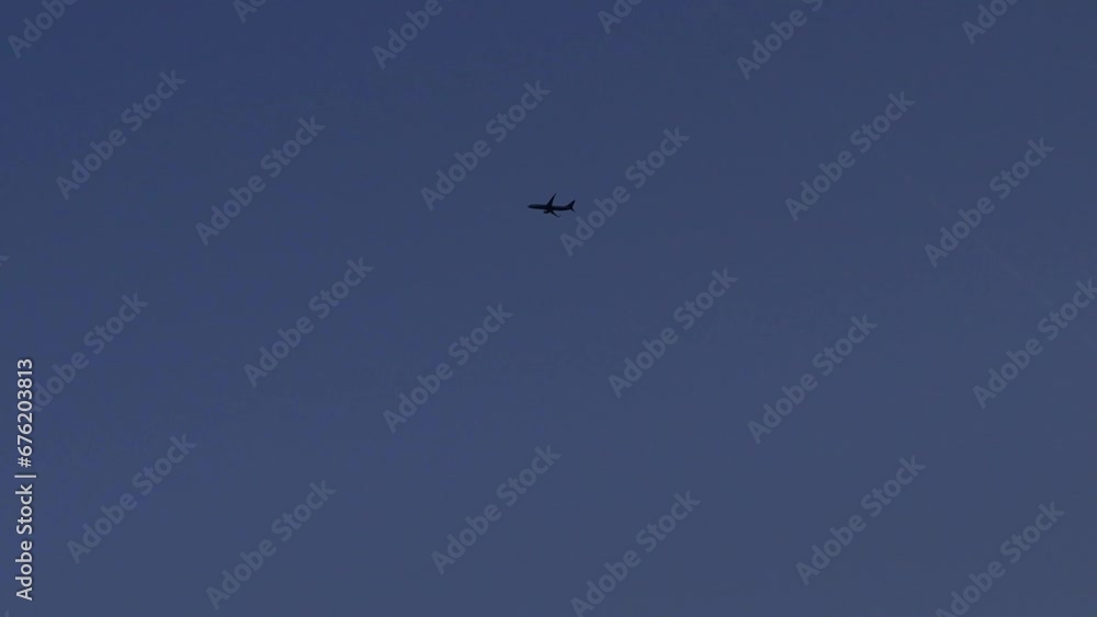 Airplane en-route to destination unknown. Deep blue sunset background Airplane en-route to destination unknown. Deep blue sunset background