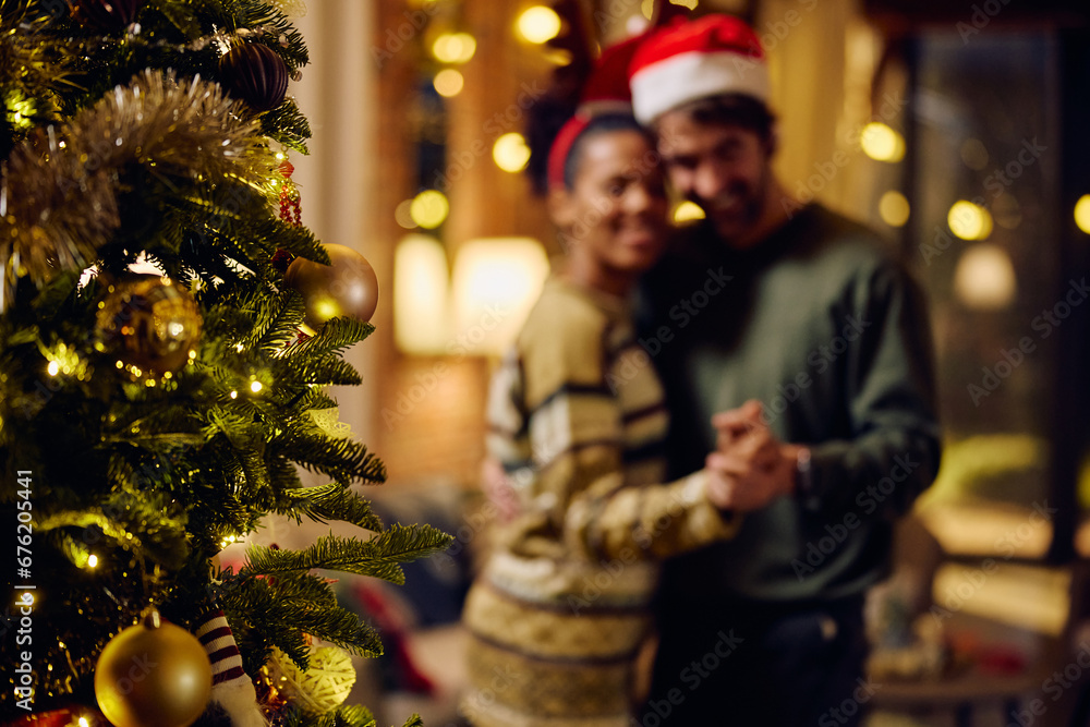 Close up of Christmas tree with couple dancing in background. Close up of Christmas tree with couple dancing in background.