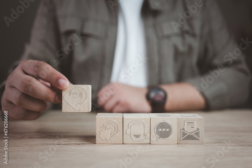 Hand holding a wooden block with dice with online network support and service. Contact us icons on wooden blocks. Various contact options concepts