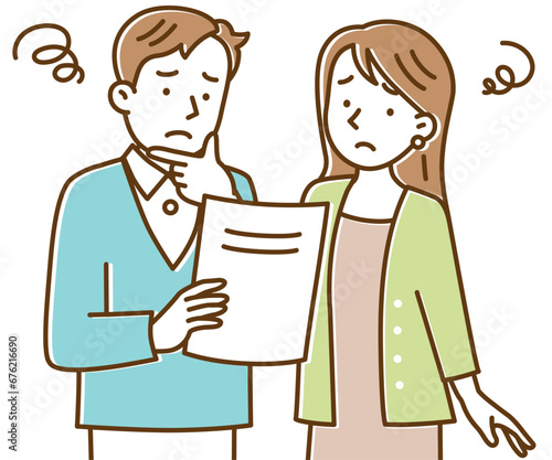 困った顔で書類を見る若い夫婦