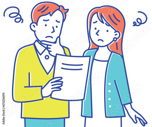 困った顔で書類を見る若い夫婦