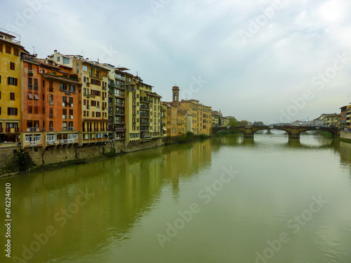 Scenic view from historic medieval Ponte Vecchio bridge on the Arno River, Florence, Tuscany, Italy, Europe. Landmark in Italian city on cloudy overcast day. Tourist travel destination