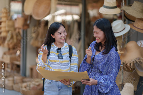 Traveler, two young female tourists, Asian backpacker with backpack looking at map The route around the craft market Weave in holiday, travel, trip and summer travel ideas.