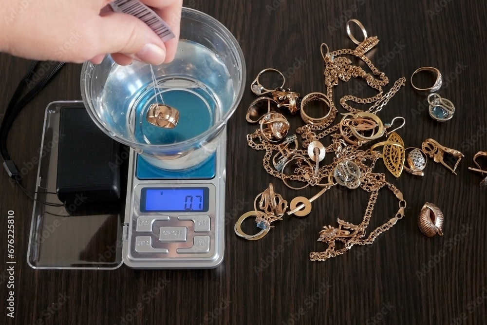 pawnshop worker determines the ring of gold jewelry using the ...