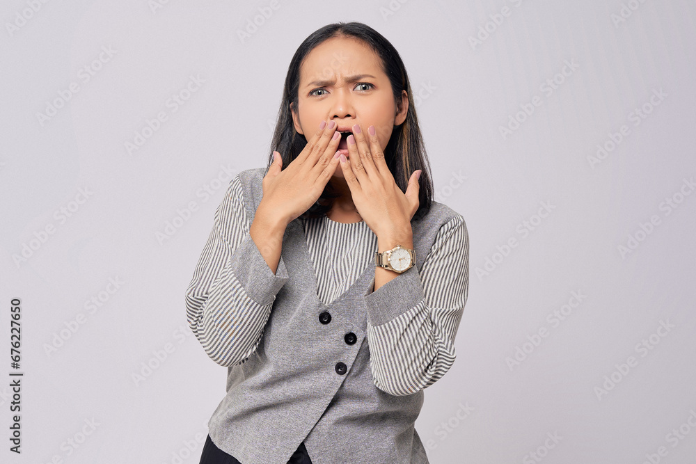 Surprised beautiful young Asian woman in casual clothes covering mouth with hand, looking at the camera with amazed facial expression isolated on white background. People lifestyle concept Surprised beautiful young Asian woman in casual clothes covering mouth with hand, looking at the camera with amazed facial expression isolated on white background. People lifestyle concept