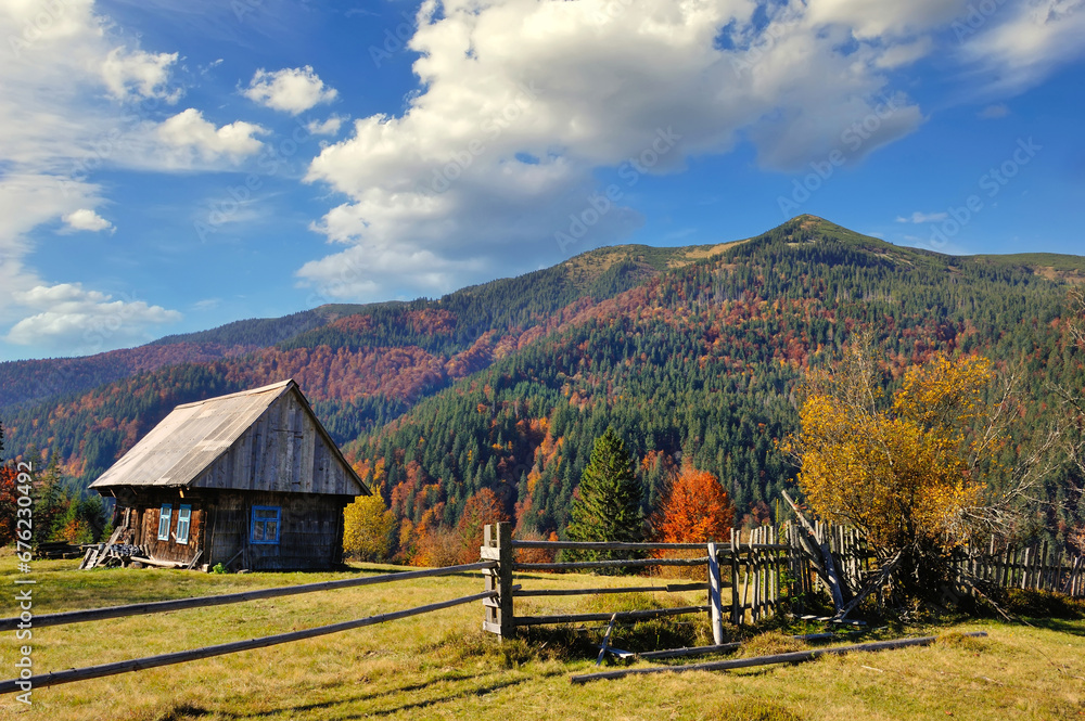 Beautiful landscape with old wooden hut in the Carpathians mountains. Autumn sunny day.