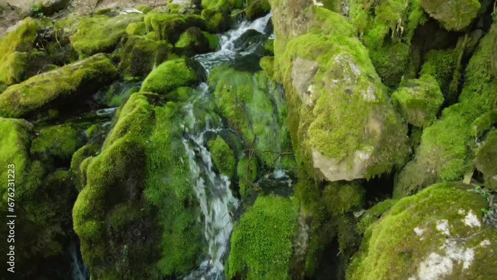 Close-up of water descending over moss-covered rocks in the woods in Serbia Close-up of water descending over moss-covered rocks in the woods in Serbia