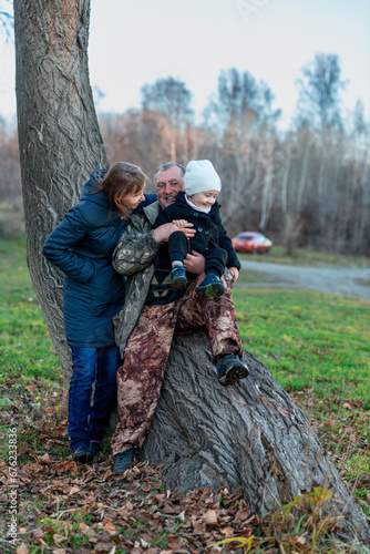 little boy in the autumn forest with his grandparents