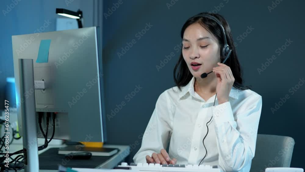 Asian businesswoman, successful call center, sitting at a table wearing headphones and talking Consulting with customers online with PC computer, online business concept. Asian businesswoman, successful call center, sitting at a table wearing headphones and talking Consulting with customers online with PC computer, online business concept.