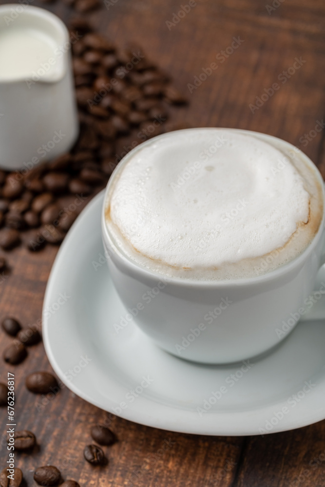 Cappuccino coffee in a white porcelain cup on a wooden table Cappuccino coffee in a white porcelain cup on a wooden table