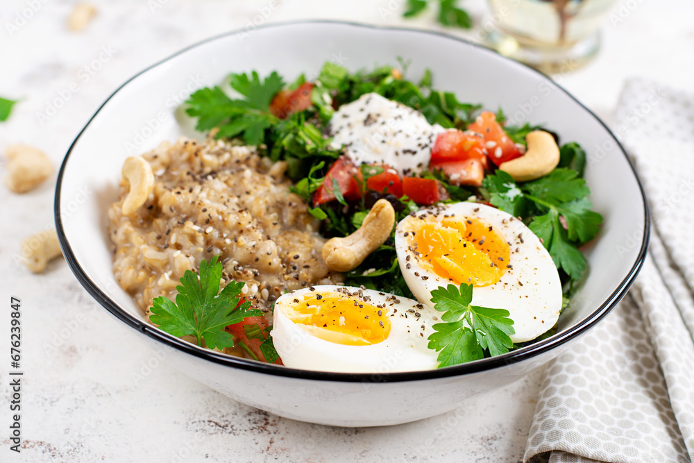Breakfast oatmeal porridge with boiled eggs and fresh salad. Healthy balanced food. Trendy food. Breakfast oatmeal porridge with boiled eggs and fresh salad. Healthy balanced food. Trendy food.