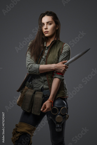 Photography Middle Eastern descent in post-apocalyptic survival gear, brandishing a dagger o