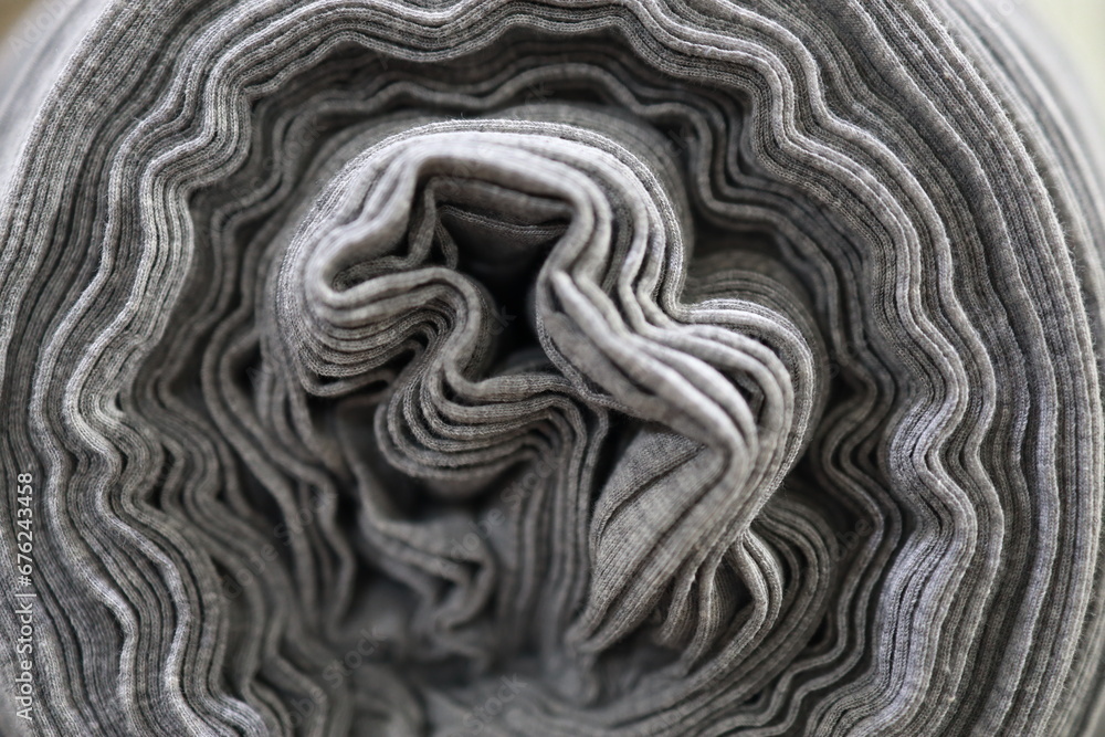 Rolled fabric on roller. Black color fabric. Rolled fabric on roller. Black color fabric.