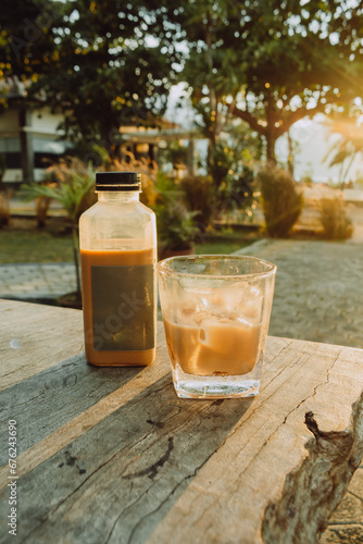 coffee bottle and glass on a wooden table in the afternoon  photo