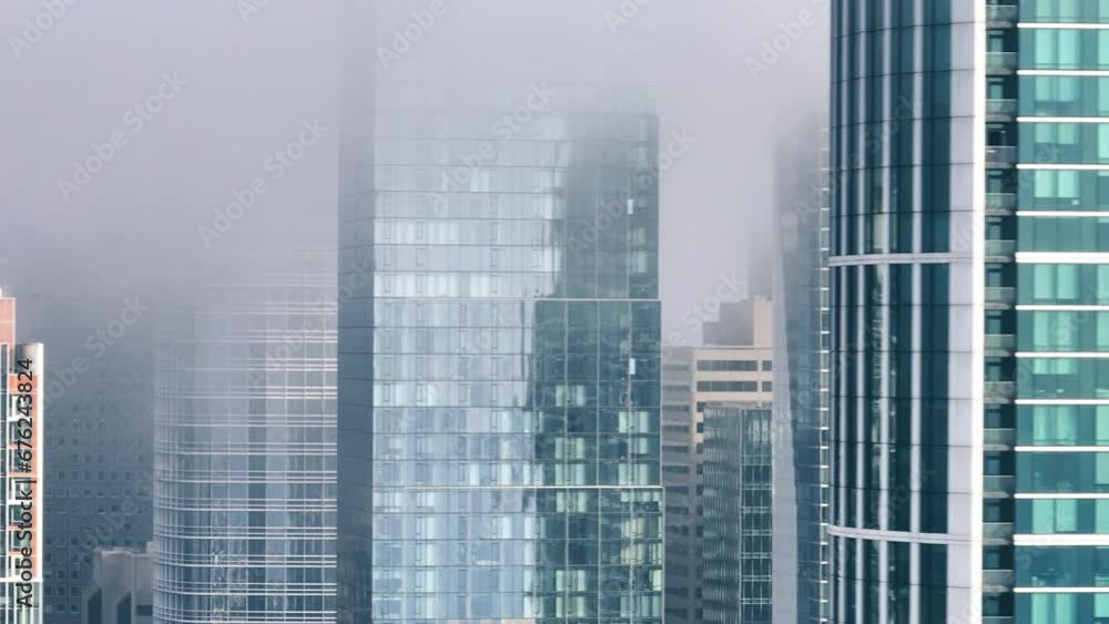 Establishing shot of dense fog in San Francisco downtown financial district, California. Aerial of San Francisco city urban futuristic skyline under fog. Concrete glass buildings high rise skyscrapers