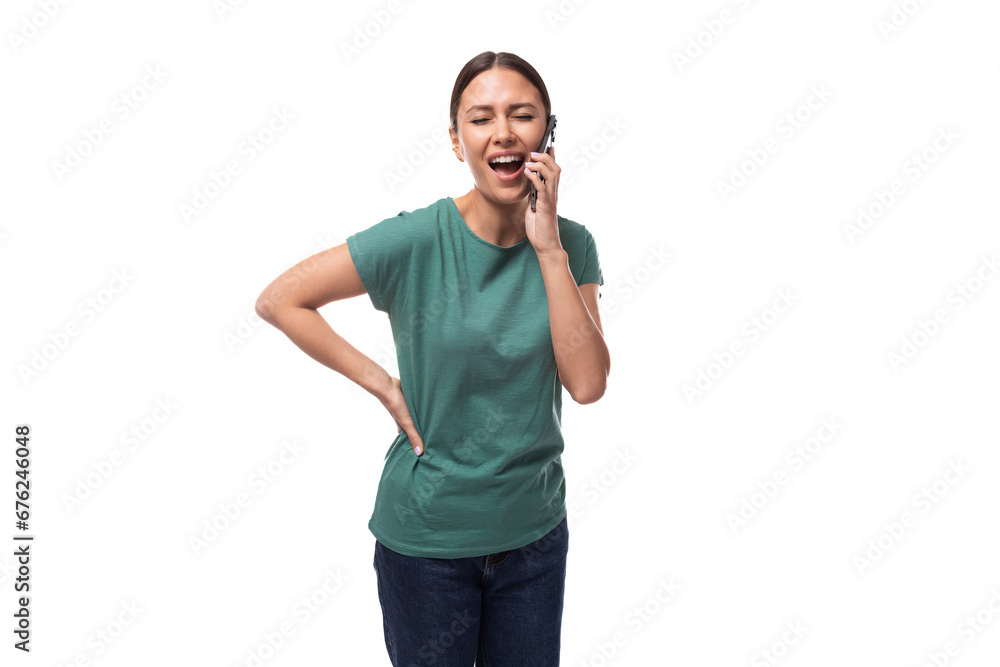 young slender european woman with a ponytail hairstyle is dressed in a green t-shirt communicates cutely on the phone young slender european woman with a ponytail hairstyle is dressed in a green t-shirt communicates cutely on the phone