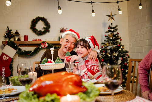 Happy and Cheerful group of extended Asian family. Granddaughter talking and smiling with grandparent during Christmas dinner at home. Celebration holiday together. Family gatherings and reunions.