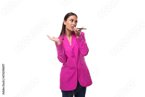 young smart european brunette with black hair is dressed in a stylish raspberry jacket talking on a smartphone