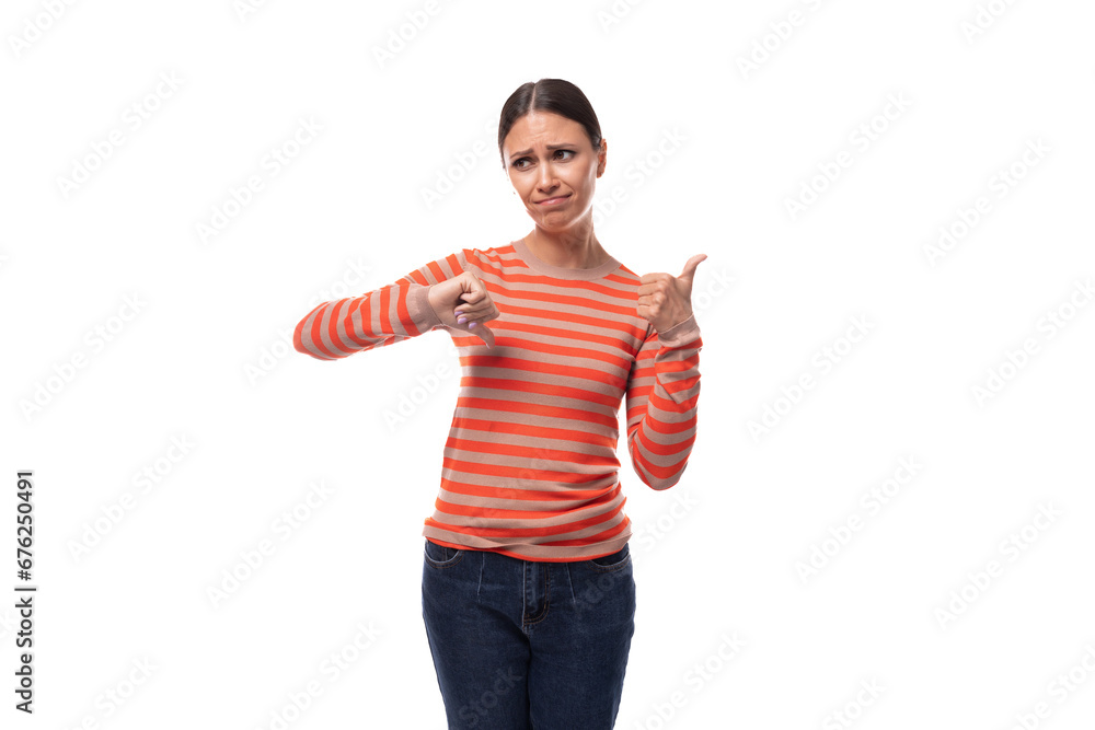 young slender adult woman with a ponytail dressed in an orange striped jacket and jeans is having doubts young slender adult woman with a ponytail dressed in an orange striped jacket and jeans is having doubts