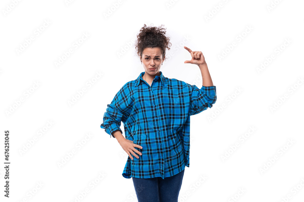 a young woman with a careless curly hairstyle dressed in a casual shirt shows the size of an object with her hands a young woman with a careless curly hairstyle dressed in a casual shirt shows the size of an object with her hands