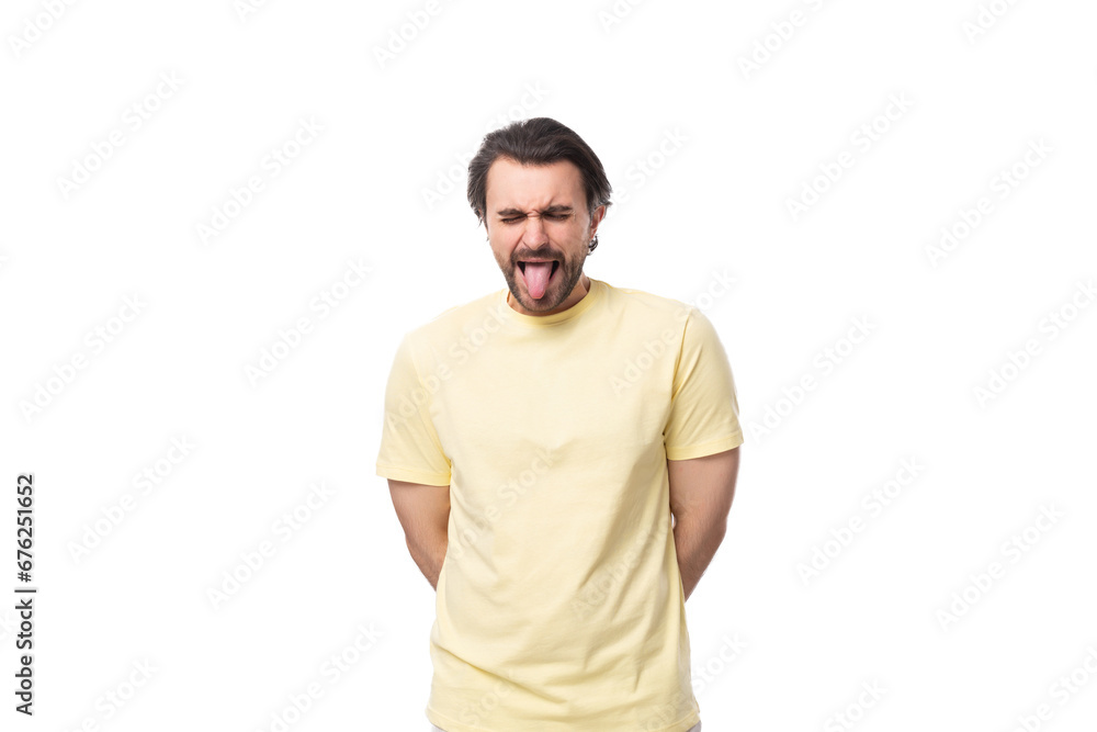 young handsome european man with beard and mustache shows tongue on white background with copy space. grimace concept young handsome european man with beard and mustache shows tongue on white background with copy space. grimace concept