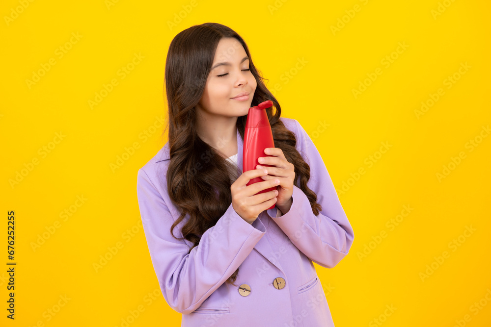 Teen child girl with shampoo bottle or shower gel isolated on yellow background. Kids hair cosmetic product. Teen child girl with shampoo bottle or shower gel isolated on yellow background. Kids hair cosmetic product.