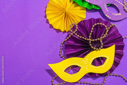 Festive Mardi Gras masquerade purple background. Fat Tuesday carnival, masks, beads, traditional decor