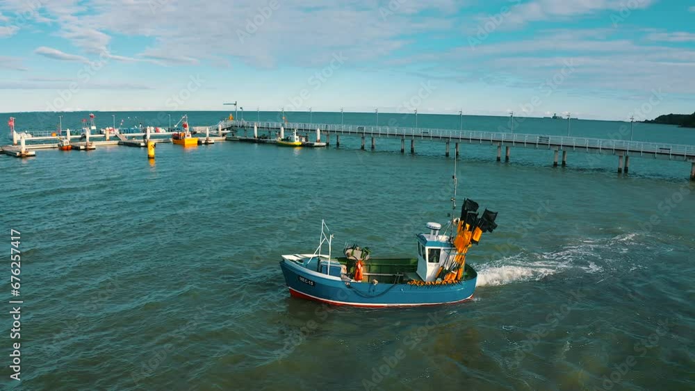 Aerial view of fishing boat on the sea with pier in the background Aerial view of fishing boat on the sea with pier in the background