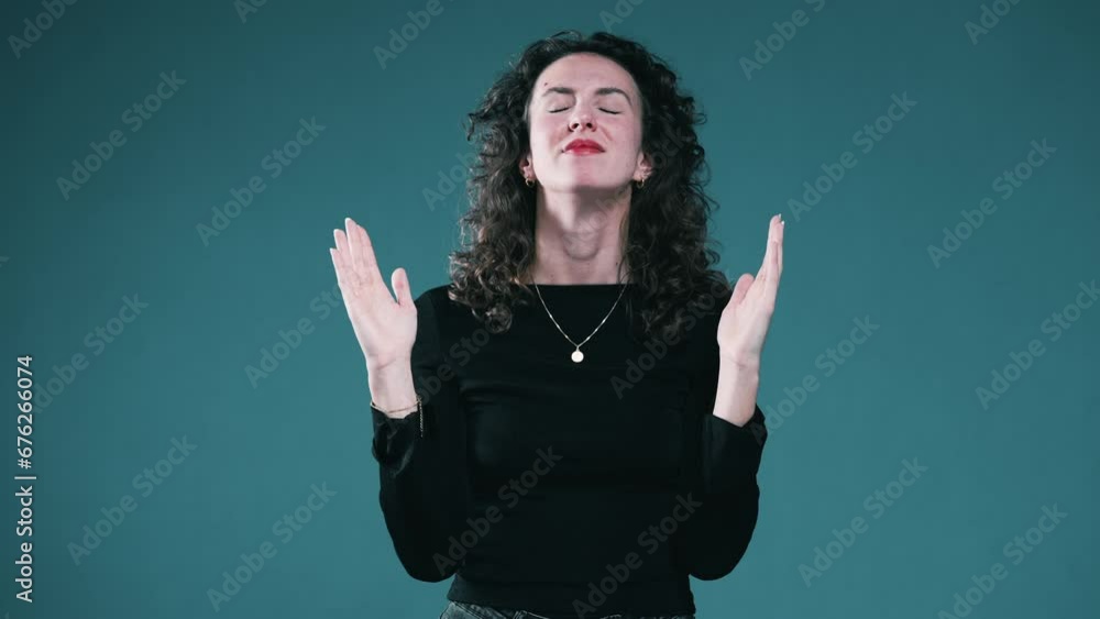 Spiritual woman in Prayer with open arms looking up with HOPE and GRATITUDE while standing on a blue background Spiritual woman in Prayer with open arms looking up with HOPE and GRATITUDE while standing on a blue background