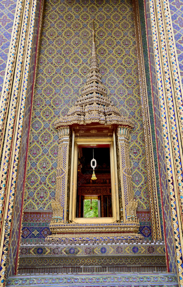 BANGKOK, THAILAND - November 16, 2023 : Golden Wood craft Thai classic pattern decorating on the Wooden cabinet frame in Thai Buddhist temple wall, Thailand.