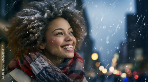 Mujer afroamericana con bufanda de pie y sonriendo en una tarde nevando en la ciudad al atardecer. 