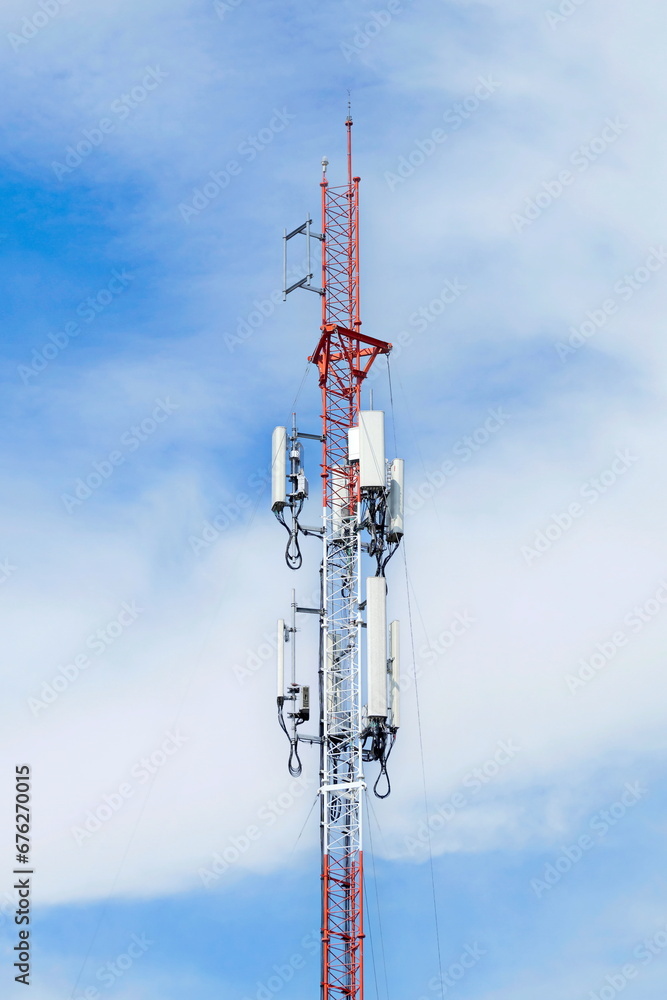 Telecommunication tower of 4G and 5G cellular. Macro Base Station. 5G radio network telecommunication equipment with radio modules and smart antennas mounted on a metal against cloulds sky background. Telecommunication tower of 4G and 5G cellular. Macro Base Station. 5G radio network telecommunication equipment with radio modules and smart antennas mounted on a metal against cloulds sky background.