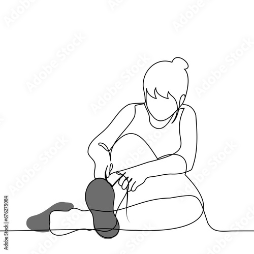 woman sitting on the floor ties a lace on a sneaker - one line art vector. concept putting on shoes, trying on shoes, tying shoelaces training