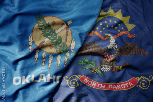 big waving colorful national flag of north dakota state and flag of oklahoma state . photo