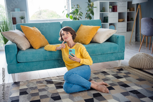 Portrait of minded dreamy adorable pretty lady sitting carpet couch thinking future weekend comfort apartment indoor room