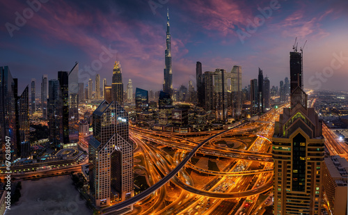 Elevated, panoramic view of the illuminated skyline of Dubai City center and busy Sheikh Zayed road intersection, United Arab Emirates, during evening time photo