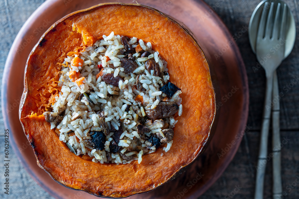 Great pumpkin baked with a filling close up. Stuffed roasted orange pumpkin, whole baked, filled with a tasty mixture of rice, raisins and spices