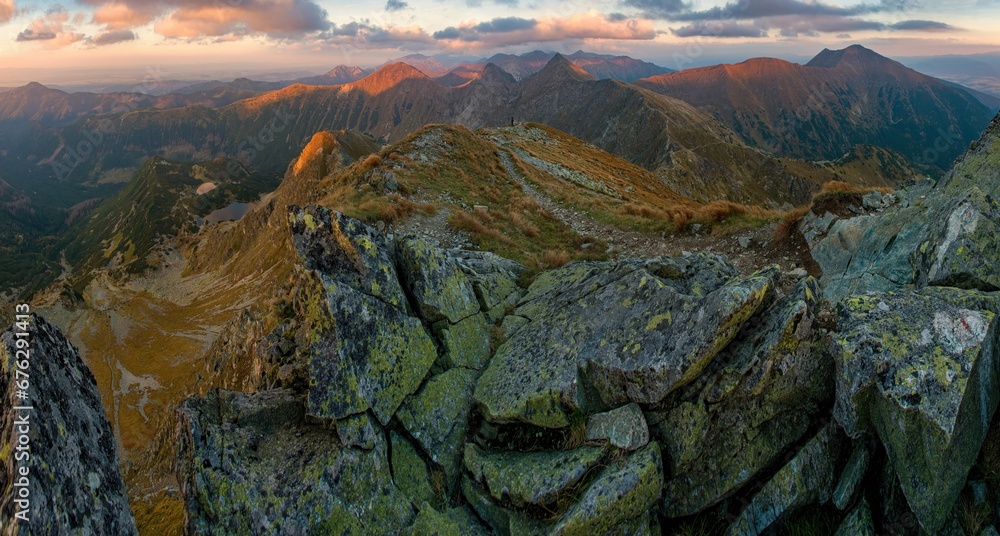 Autumn hiking in the mountains with massive rocks, dramatic skies and majestic mountains. Panorama Mountain sunset in Slovakia mountain - Rohace, Mountain hiking holiday Western Tatras.