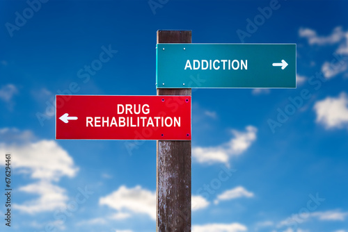 Addiction vs Drug Rehabilitation - Traffic sign with two options - appeal to overcome addictive substance abuse and dependence through detoxification, treatment, rehabilitation and abstinence.
