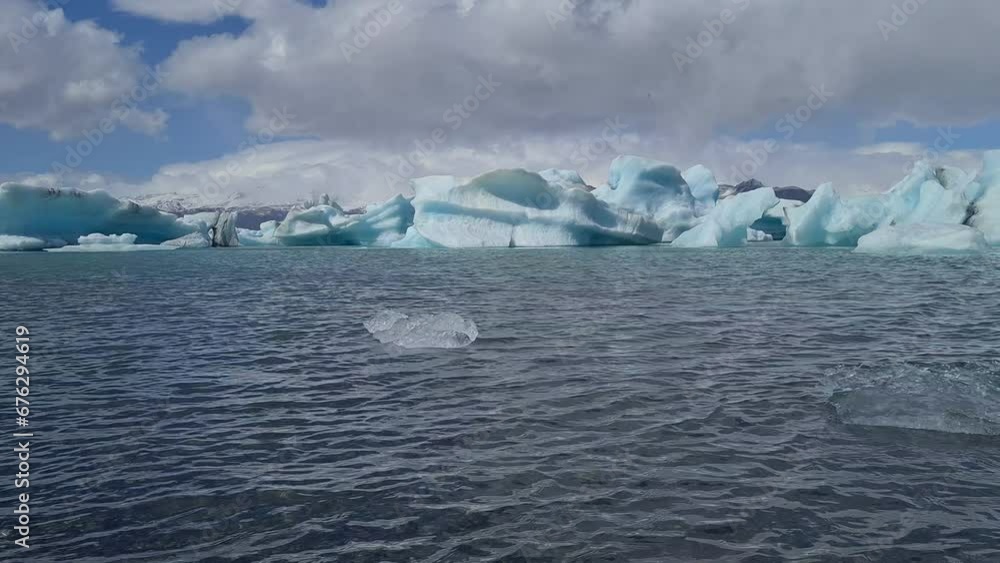 Icebergs and Pieces of Ice in Cold Sea Water, Glaciers Melting on Warm Sunny Weather Icebergs and Pieces of Ice in Cold Sea Water, Glaciers Melting on Warm Sunny Weather