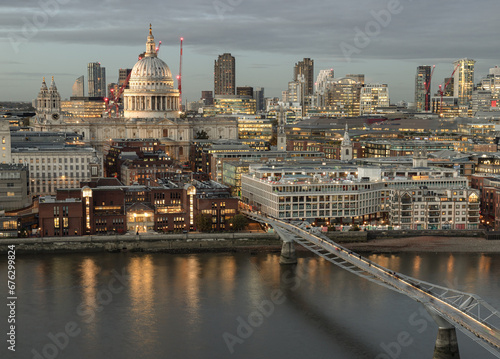 Aerial view of The City of London on the Other Side of Thames River, With St. Paul's Cathedral Rising Above All the Other Buildings with Millennium Bridge at dusk. View of Modern buildings of the Lond